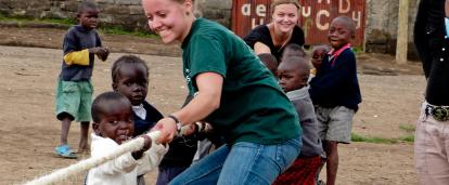 Projects Abroad volunteers work with children in Ghana. Childcare volunteer plays a game with children during her work experience in Ghana.